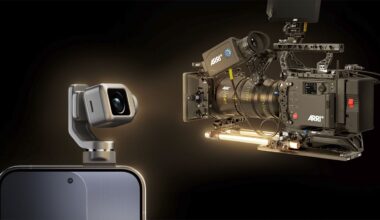 A close-up of a smartphone with a small camera module attached, facing a large professional ARRI cinema camera against a dark background. Both cameras are highlighted, emphasizing a contrast in size and technology.