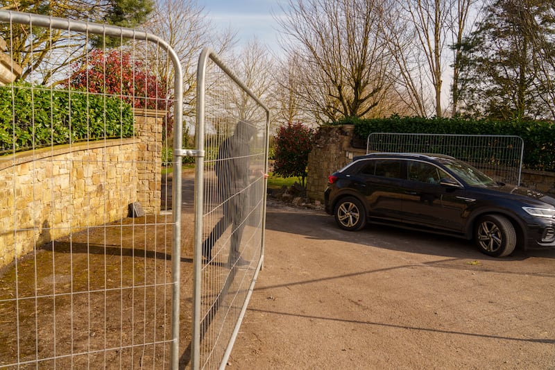 A security staff member moves fencing across the drive way into the house on Friday. Photograph: Barry Cronin