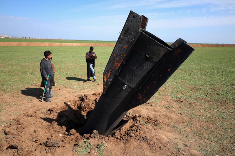People stand next to an Iranian missile after it fell near Qamishli International Airport, near the Turkish border in the Qamishli district of Hasakah, Syria, on March 4th, 2026. Photograph: Amjad Kurdo / Middle East Images / AFP via Getty Images