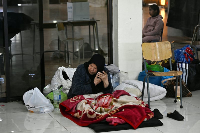 A woman listens to her phone inside a school transformed into a shelter for displaced people in the town to Dekwaneh, north of Beirut on Thursday. Photograph: Joseph Eid / AFP via Getty Images