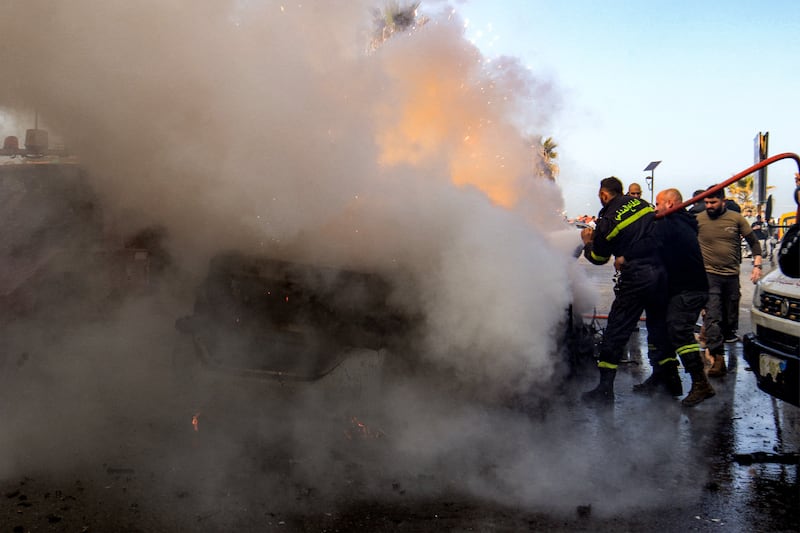 Firefighters extinguish a burning destroyed vehicle that was targeted by Israeli bombardment in Lebanon's southern coastal city of Sidon. Photograph: Mahmoud Zayyat / AFP via Getty Images
