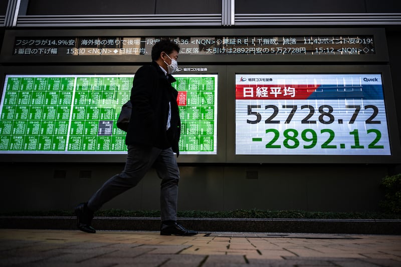 A man walks past an electronic display of the Nikkei Stock Average on the Tokyo Stock Exchange in Tokyo. Photograph: Philip FONG/AFP via Getty Images