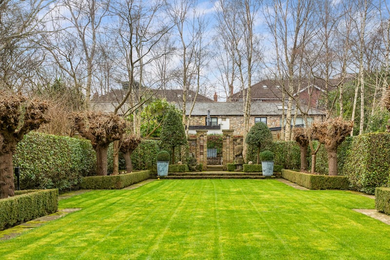 Gated coach house sits to the rear of the garden