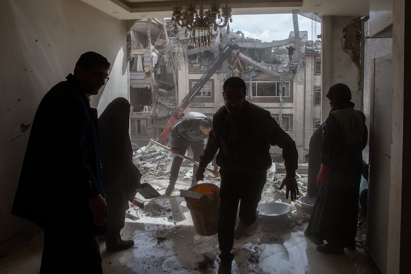 People clean up rubble in an apartment damaged by air strikes in Tehran, Iran, on Friday, March 27th, 2026. Photograph: Arash Khamooshi/The New York Times
                      