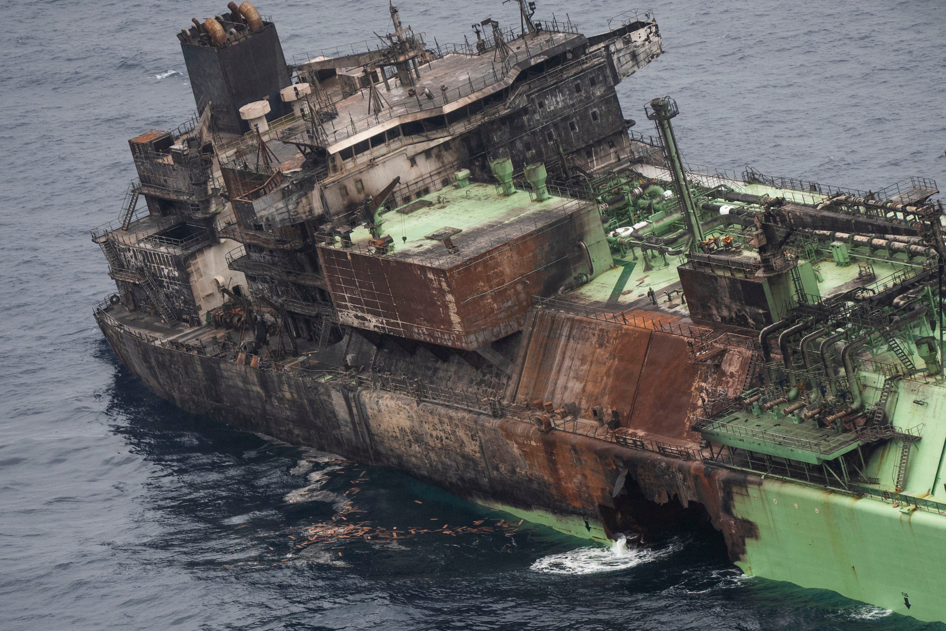 Fuel and natural gas are pouring into the sea through a gaping hole in the tanker