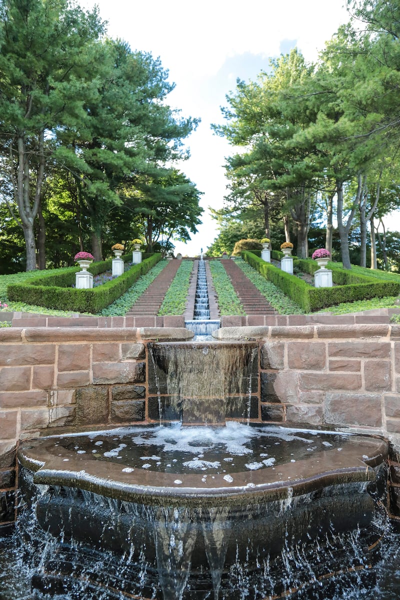 The sloping hill behind the manor includes a waterfall sculpted into a stone passageway. Photograph: Eric Striffler/New York Times