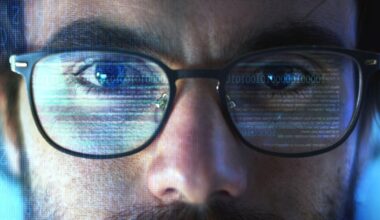 Close-up of a person's face with glasses reflecting computer code and binary numbers, suggesting intense focus on a digital screen, technology, or cybersecurity.