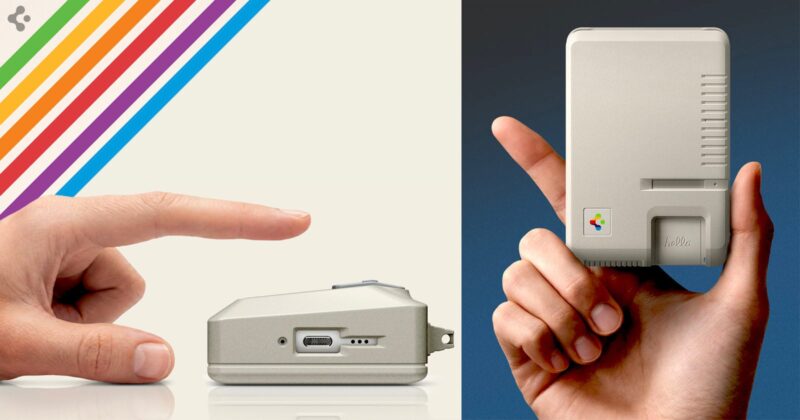 A hand points to a small, vintage computer device lying on its side. Another hand holds a similar device upright. Both devices are beige with retro design elements and colorful stripes in the background.