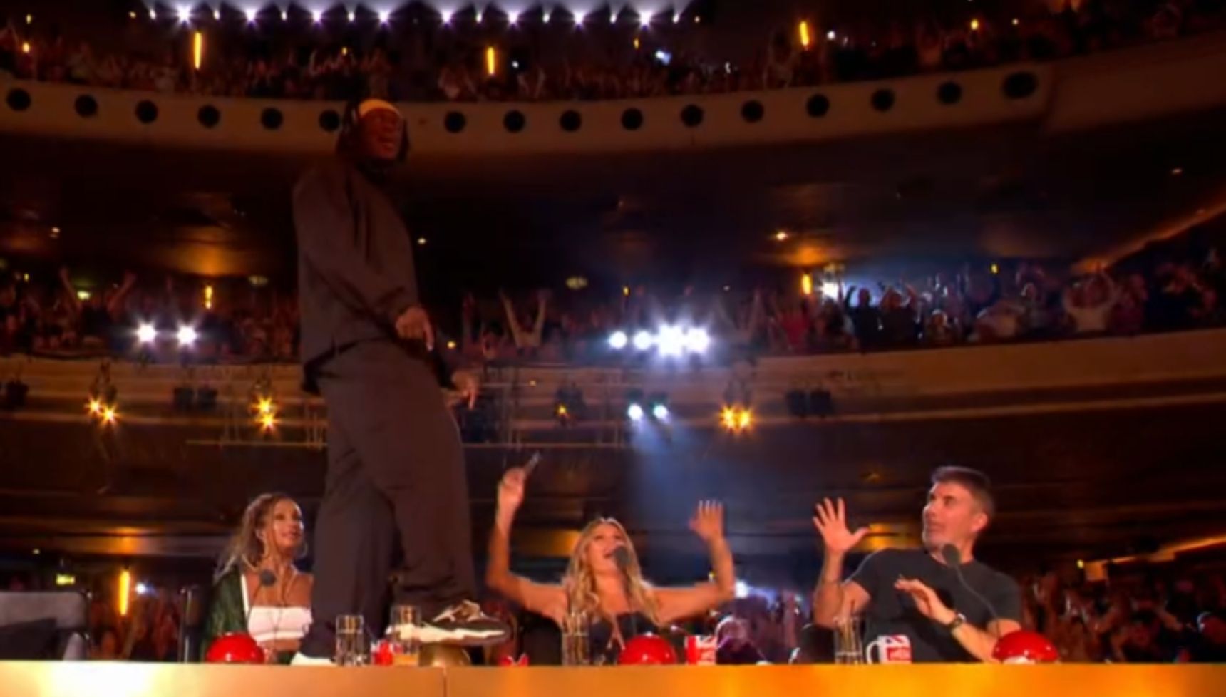KSI on the judges desk pressing the golden buzzer 