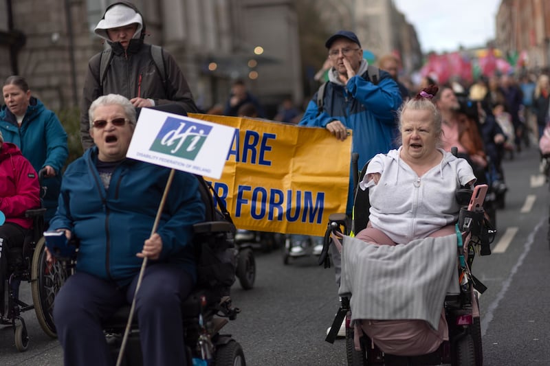 People take part in a disability rights protest march in Dublin, calling for the instatement of an emergency €400 payment for disabled people and carers. A number of one-off payments in previous budgets were not carried through to Budget 2026. Photograph: Chris Maddaloni/The Irish Times 