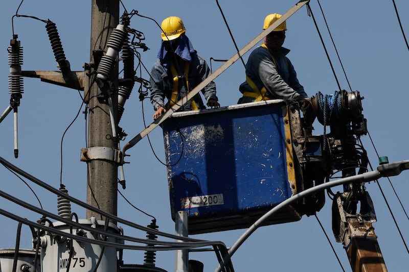 Workers from an electricity distribution company conduct repairs on power lines in Quezon City, Metro Manila. Philippine president Ferdinand Marcos Jr has declared a state of national energy emergency amid surging fuel prices in the country, impacted by the Middle East conflict. 