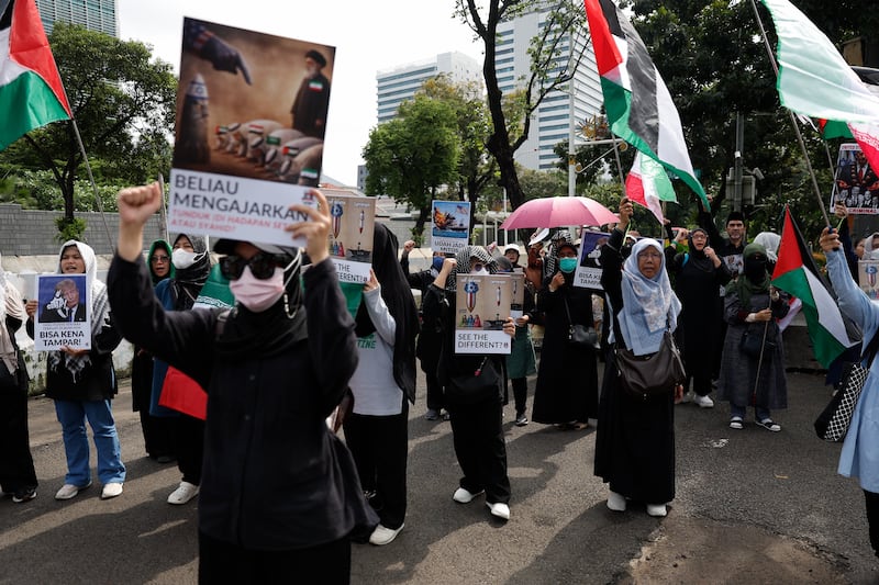 Protesters hold placards during a rally in solidarity with Iran outside the US embassy in Jakarta, Indonesia