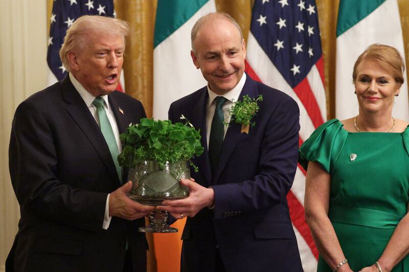 Micheál Martin presents Donald Trump with a bowl of shamrock on Tuesday, as his wife Mary O'Shea looks on, at the annual St Patrick’s Day event in the East Room of the White House. Photograph: Alex Wong/Getty