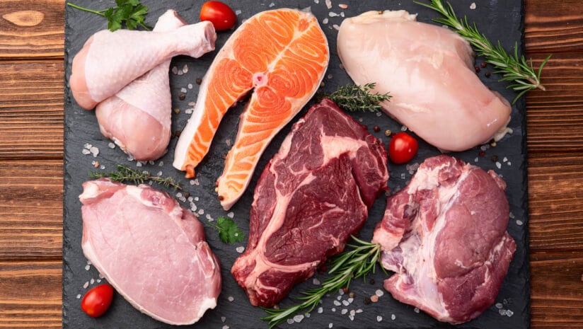 Picture of a board with salmon, beef, chicken and pork representing the primary sources of dietary creatine.