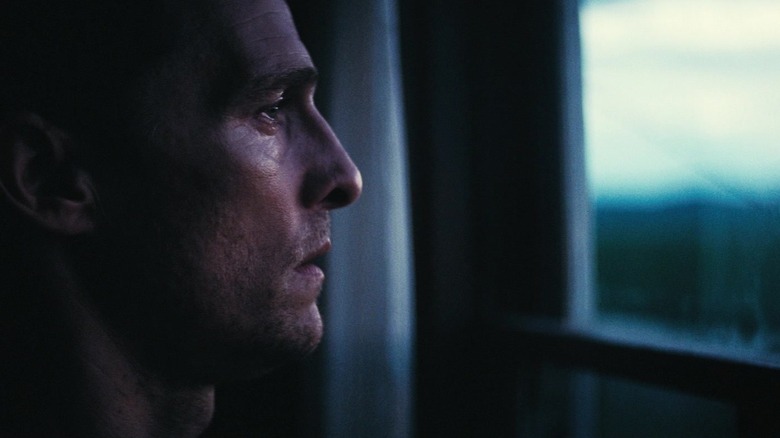 Matthew McConaughey's Joseph Cooper looks out a window at sunrise in Interstellar