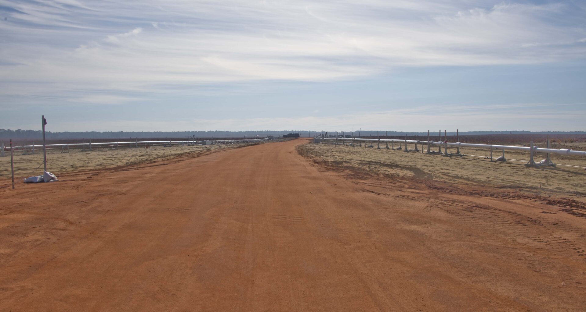 Cryogenic transfer lines on both sides of a road leading to the test article area at Eglin Air Force Base.
