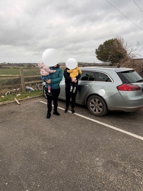 The family are pictured beside the car where they slept every night in a car park in Louth. They have asked not to be identified.