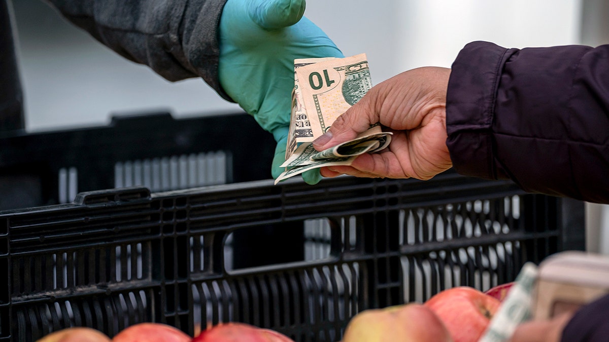 A person hands over cash to a vendor.