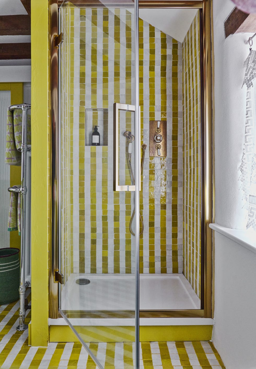 shower area with striped yellow and white tiles