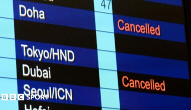 Cancelled flights to Dubai and Doha shown on flight information display at Hong Kong International Airport