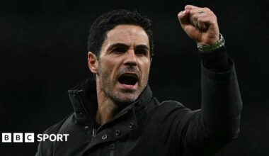 Arsenal manager Mikel Arteta, wearing a black coat, gives a clenched-fist celebration