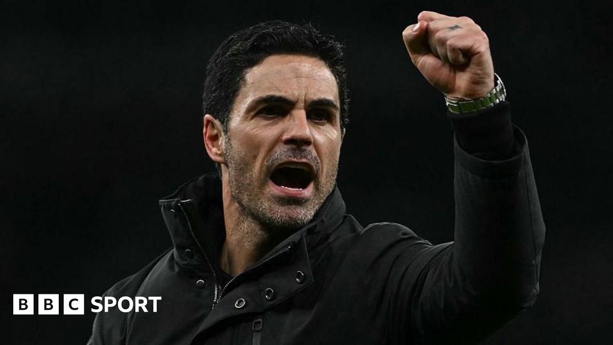 Arsenal manager Mikel Arteta, wearing a black coat, gives a clenched-fist celebration
