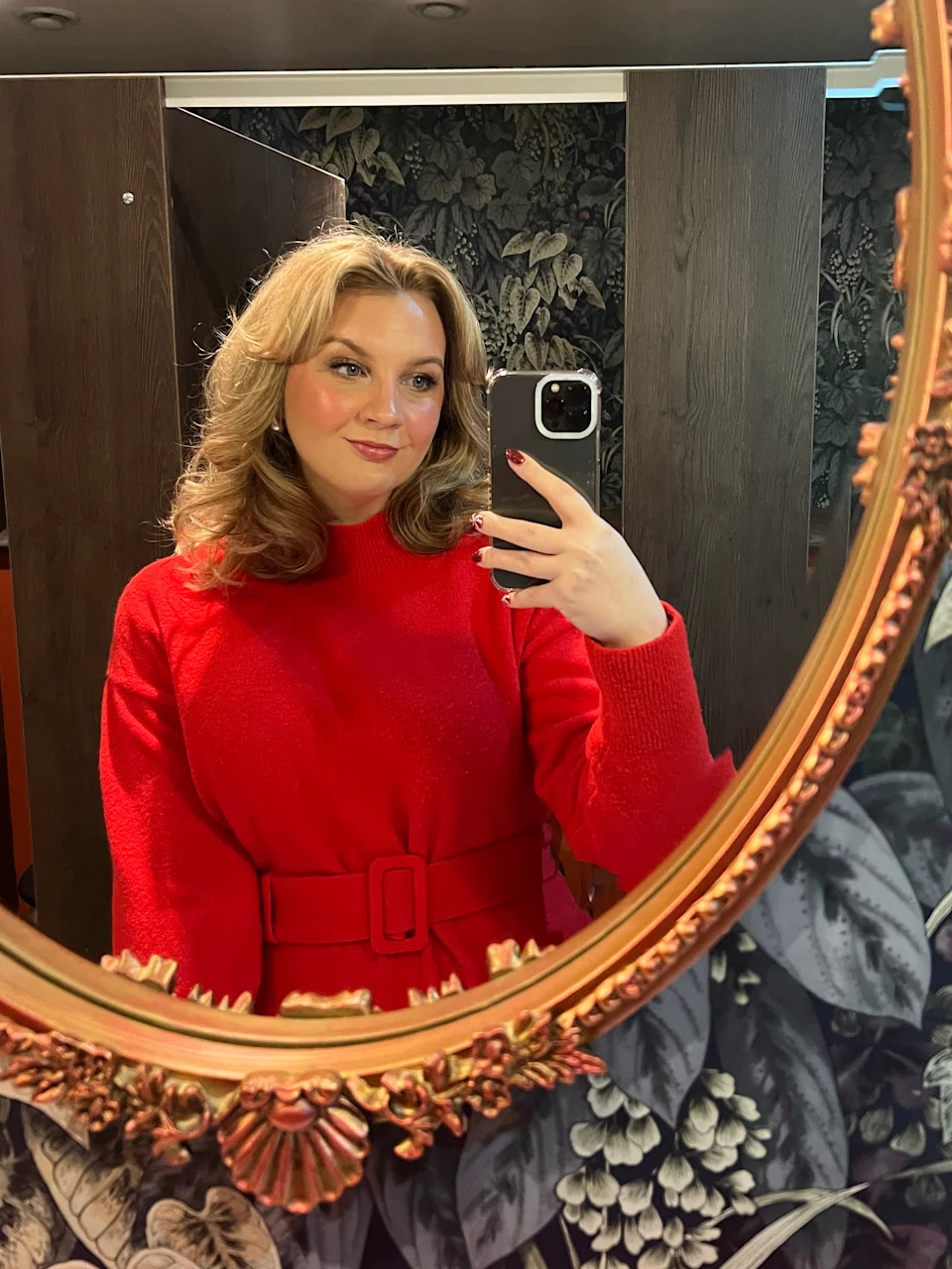 Katie in a red dress taking a mirror selfie