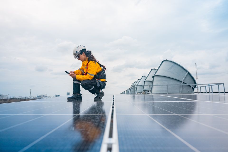 An engineer carries out a maintenance check on a ‘field’ of solar panels, which cover vast areas in many countries. Stock image/Getty