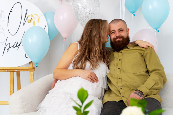 Pregnant woman and partner surrounded by balloons at a gender reveal party with emotional family dynamics highlighted.