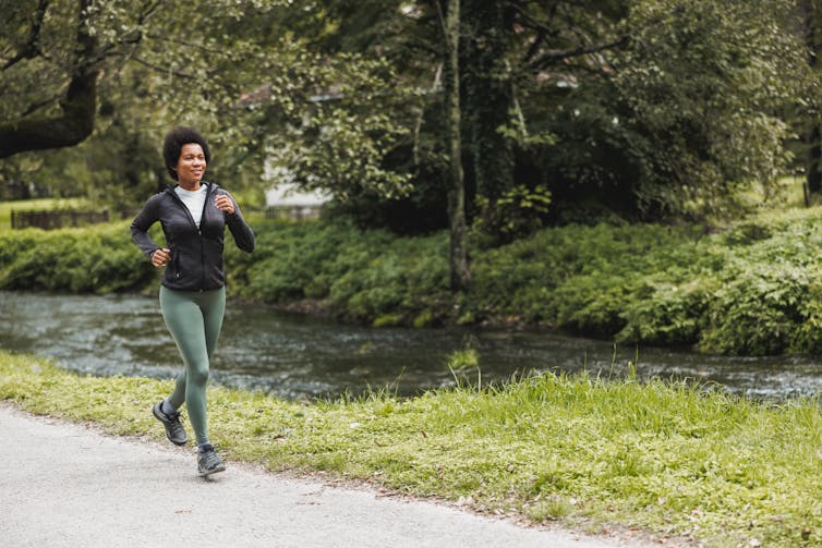 A woman goes for a jog in a park.