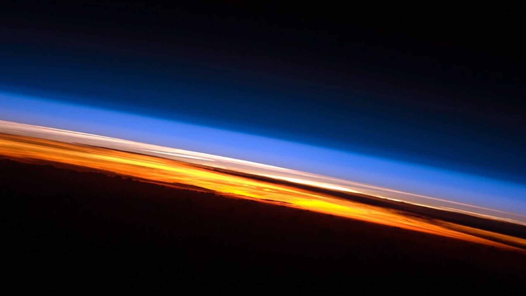 A digital rendering of a hazy, deoxygenated future Earth orbiting a brightening Sun, illustrating atmospheric collapse.