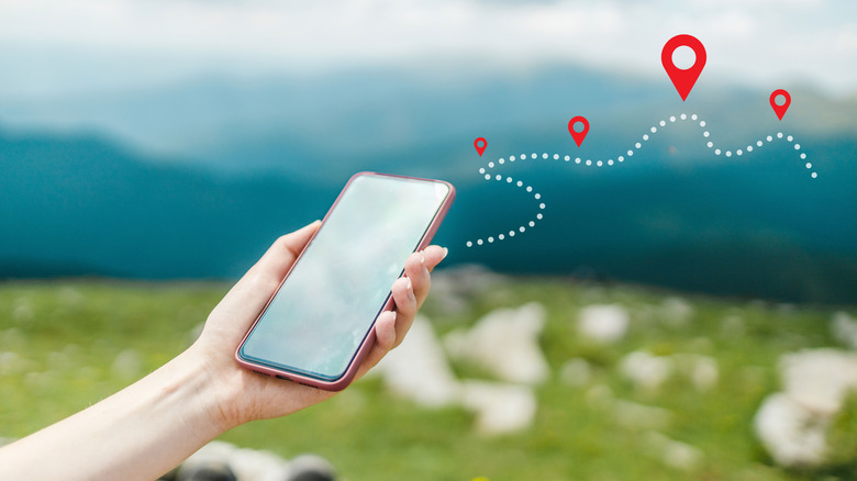 someone holding a smartphone showing location pin symbol for tracking location