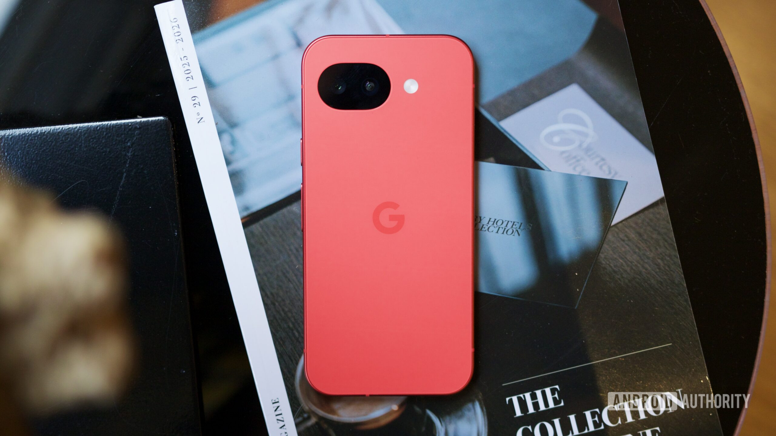 The Berry Google Pixel 10a lying face down on a coffee table.
