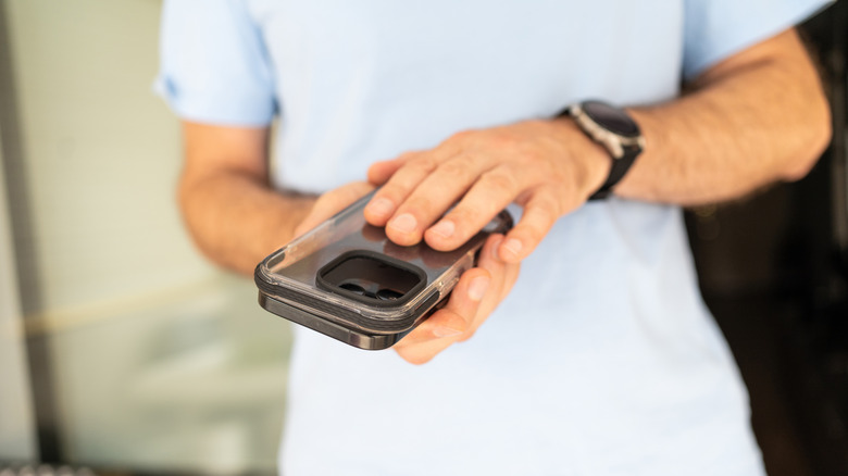 A person installing a case on their smartphone