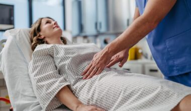ER doctor palpating woman's abdomen, using hands and steady pressure.
