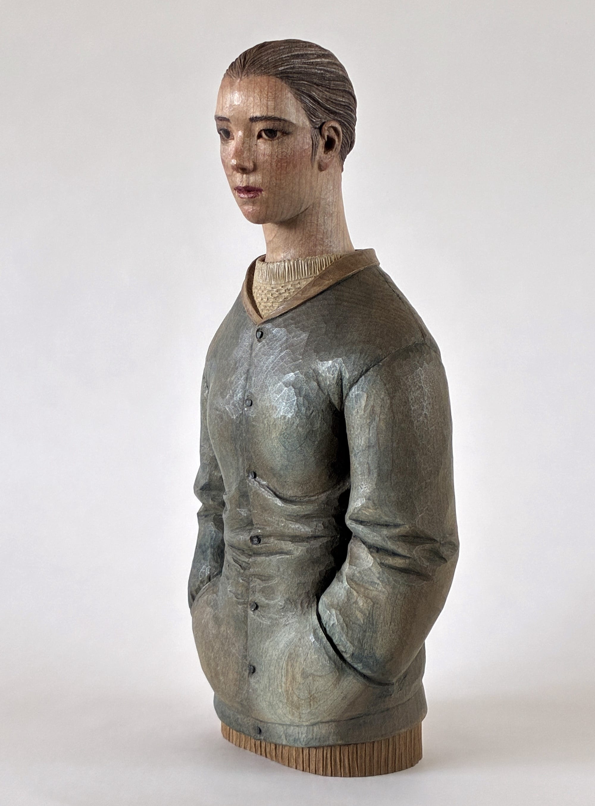 A figurative, painted wood sculpture of a young man in three-quarter profile by Shinsuke Inoue