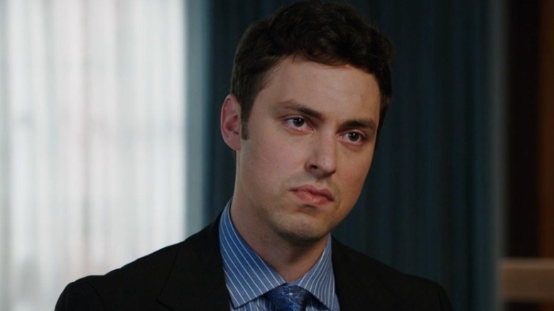 Sweets (John Francis Daley) standing in a room with blue curtains on Bones