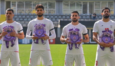 Iran wear black armbands and hold schoolbags during national anthem before match