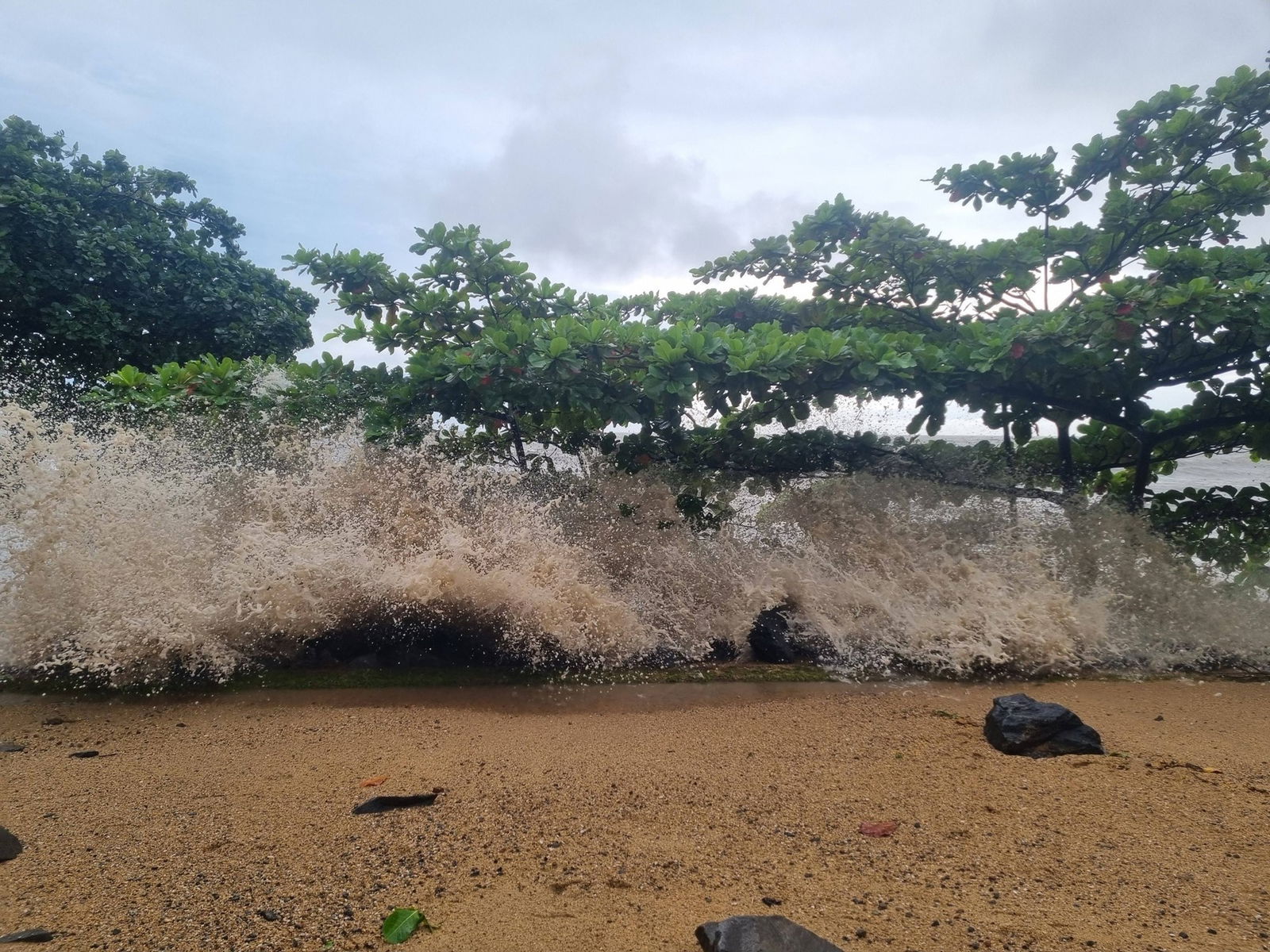a wave breaking on a beach during cyclone