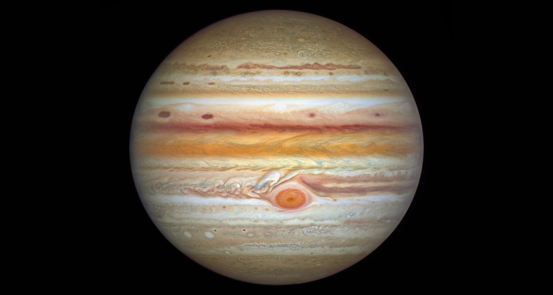The gas giant Jupiter is pictured against a black background in an image captured by the Hubble Space Telescope. Multi-coloured cloud bands and storms are visible on its surface, as is the Great Red Spot.