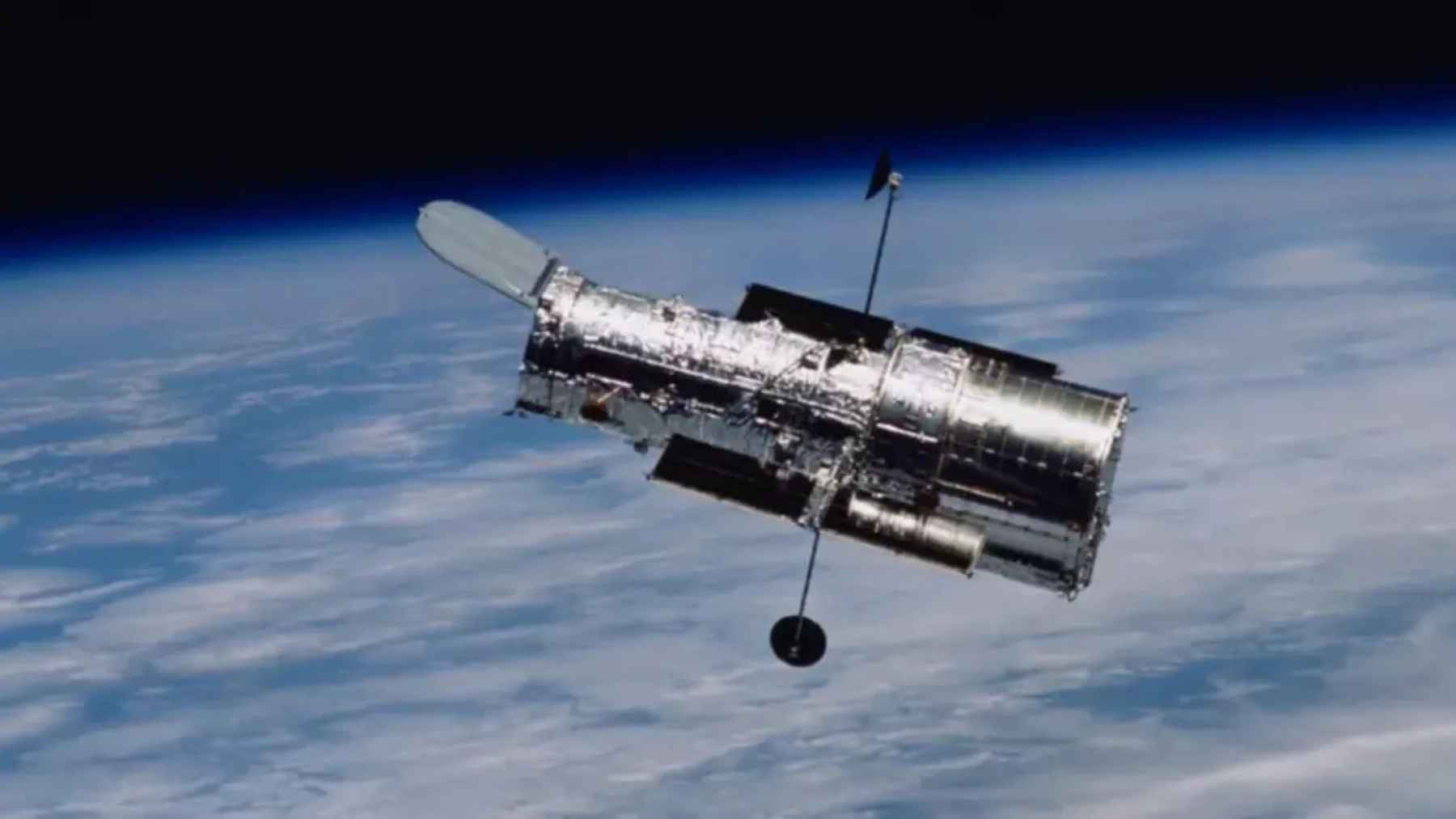 NASA Hubble Space Telescope orbiting Earth during discovery of starless Cloud-9