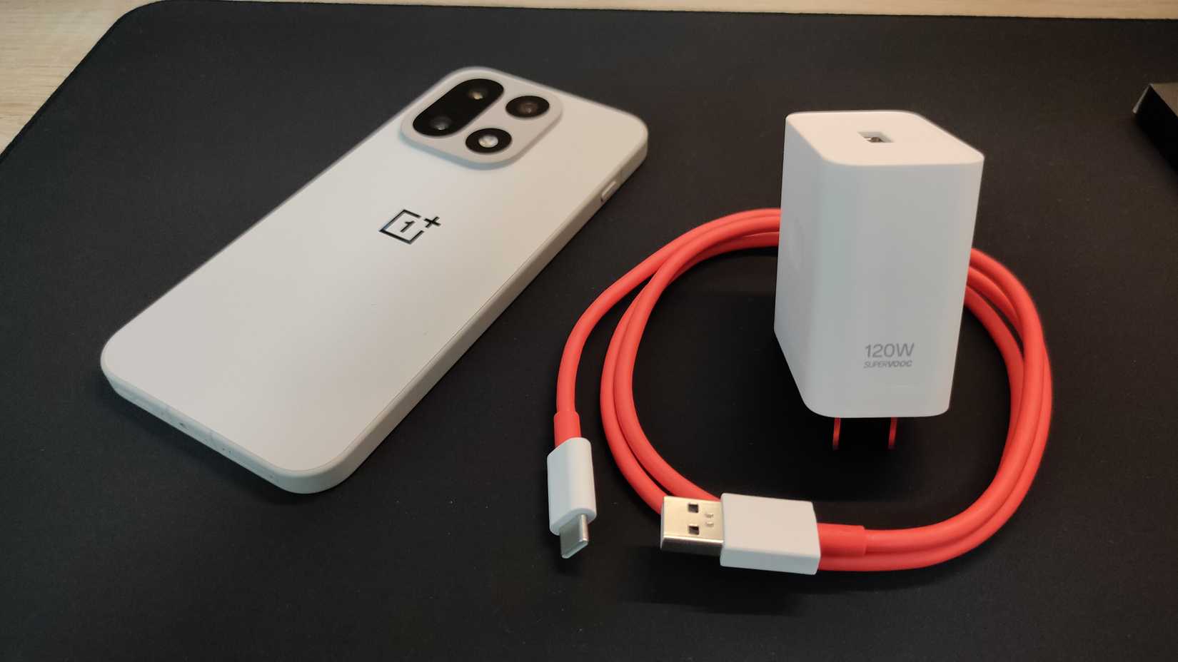 The OnePlus 15 and its 120W SuperVOOC charger.