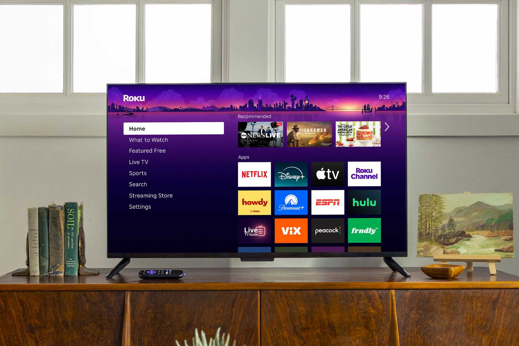 The updated Roku TV landing page on a TV on a shelf.