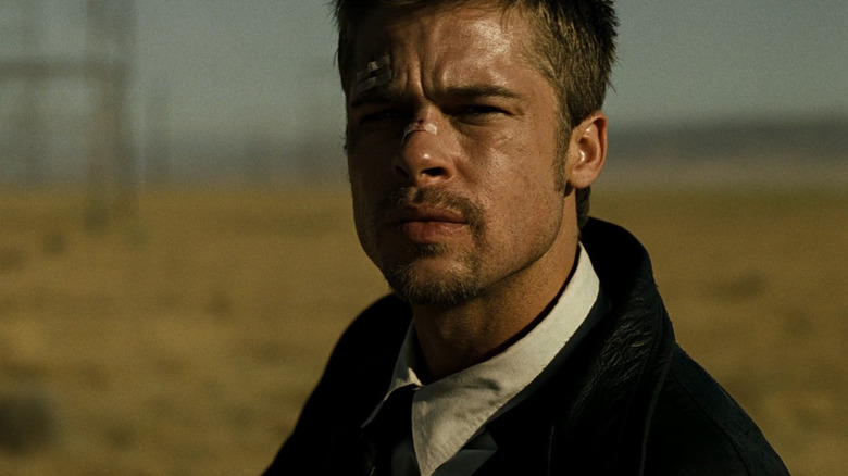 Brad Pitt as detective David Mills standing in a field looking very concerned in Se7en