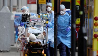Medical workers move a patient between ambulances during the COVID pandemic. Pic: Reuters