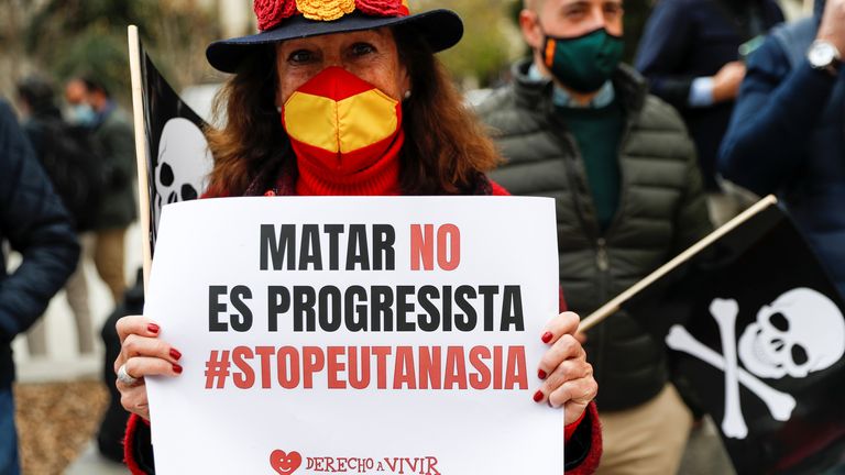 An anti-euthanasia protester in 2021 holds a sign saying: 'Killing is not progressive. Stop euthanasia'. File pic: Reuters