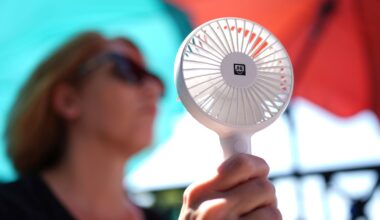 A woman cools herself with a hand fan in Hamburg during a heatwave in Germany in July 2025. Pic: AP