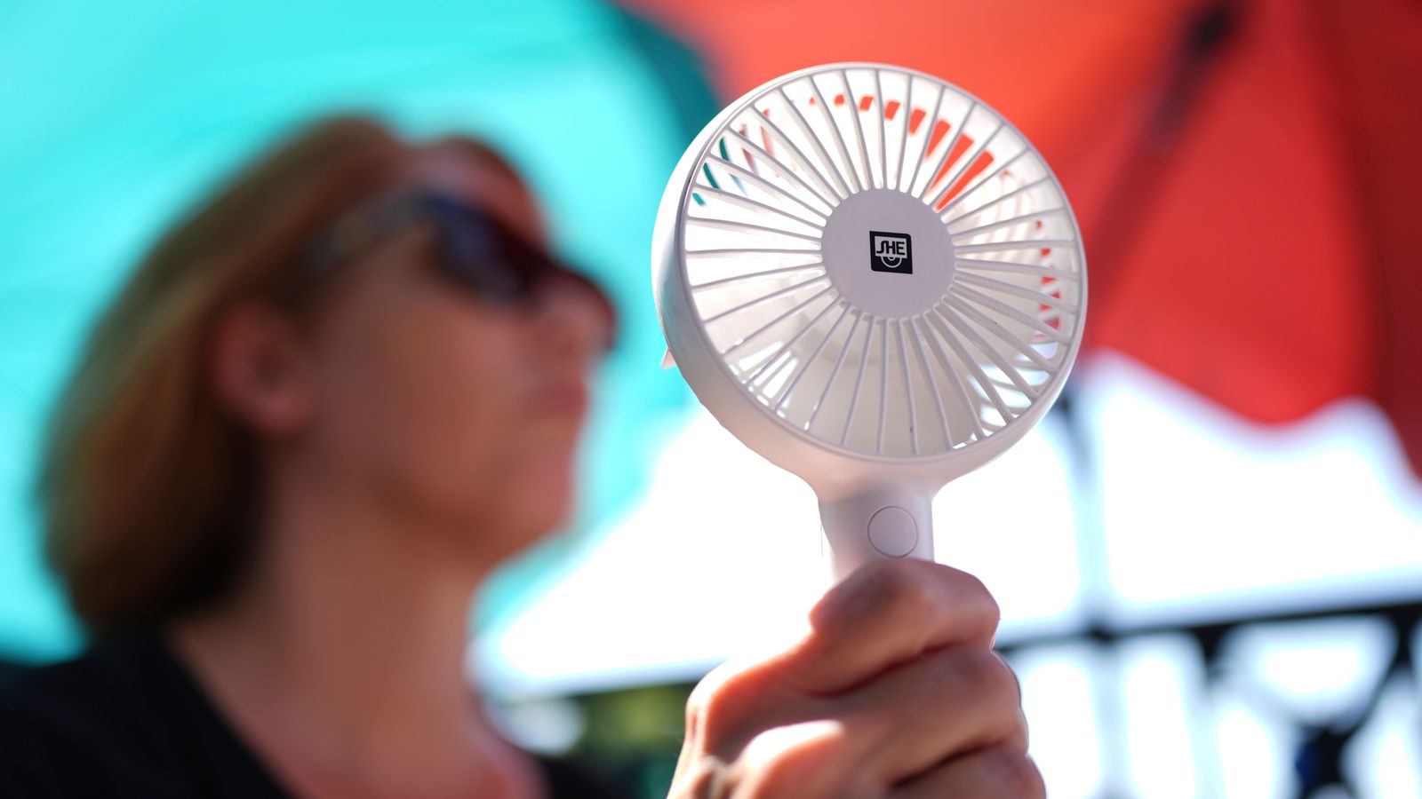 A woman cools herself with a hand fan in Hamburg during a heatwave in Germany in July 2025. Pic: AP