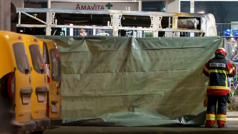 Firefighters and police officers install barriers to secure the area. Pic: AP