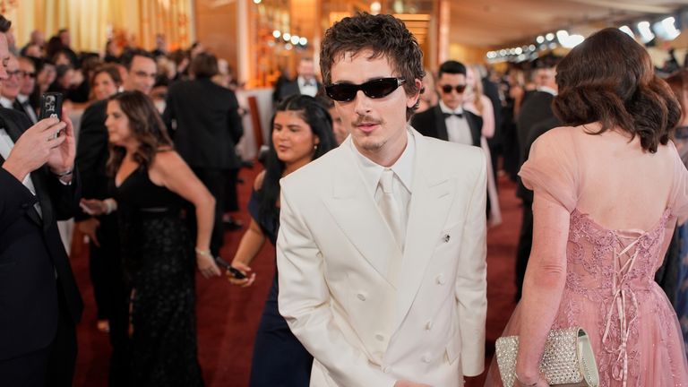 Timothee Chalamet goes for all white - bar the shades. Pic: AP